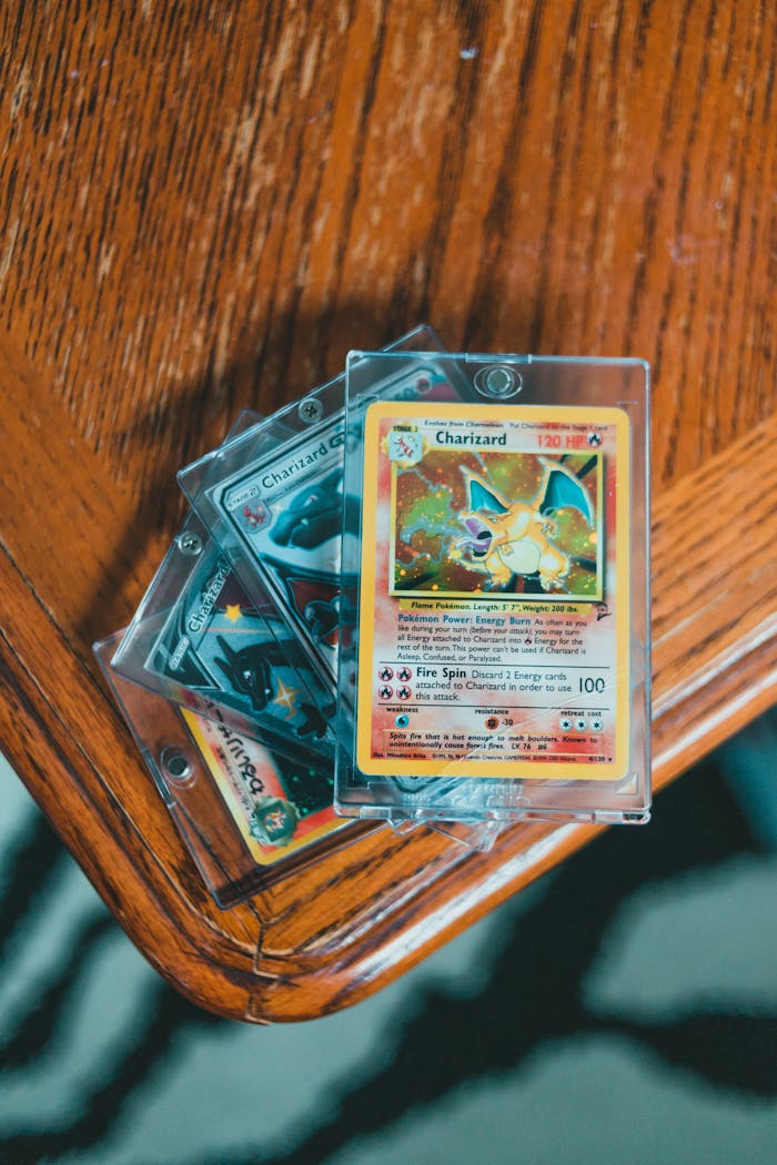 A set of valuable Pokemon trading cards displayed in protective cases on a wooden table.